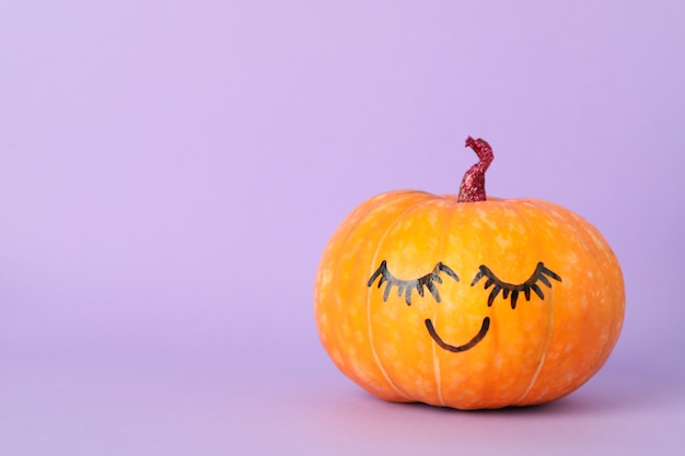 pumpkin with smile on violet, space for text