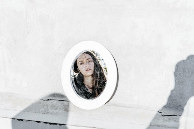Reflection of woman in mirror against wall