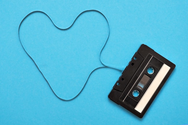 Retro music audio tape on blue baclground Tape formed in heart sign