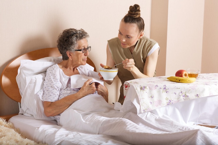 Fotografie senior social care assistant feeds an old woman of 80 years old