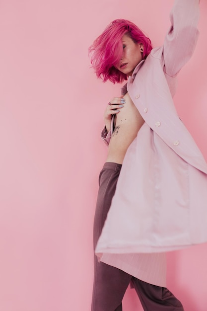 sensuous young woman covering breast while standing against colored background
