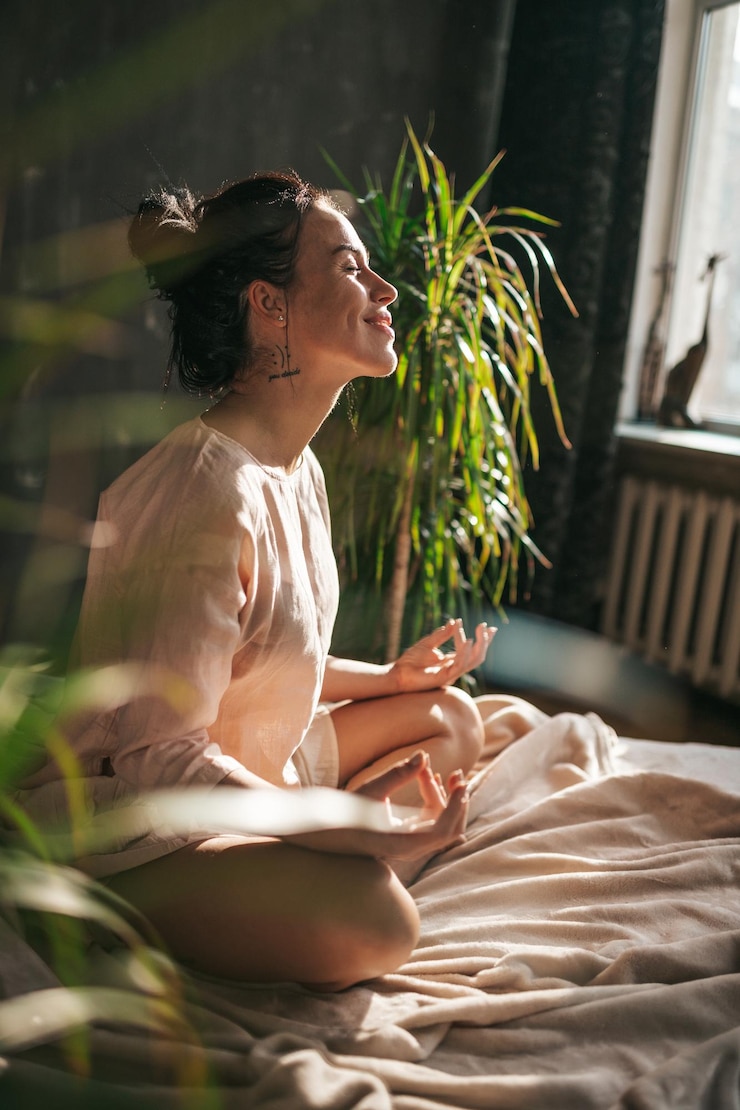 Fotografie side view of young woman sitting on bed