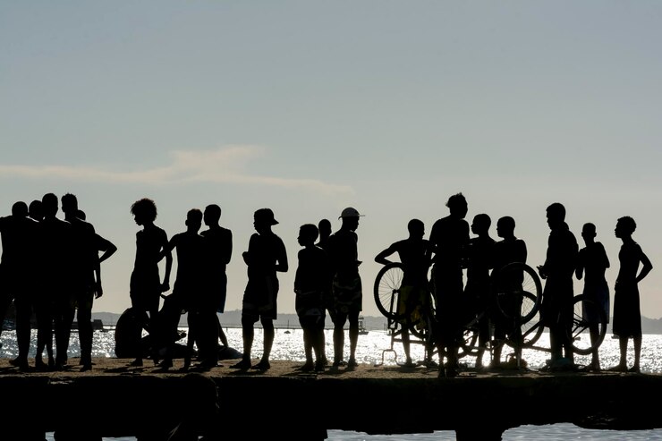 Fotografie silhouette of young people jumping from the crush bridge at the yellow sunset