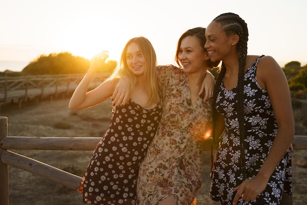 smiling friends standing at beach