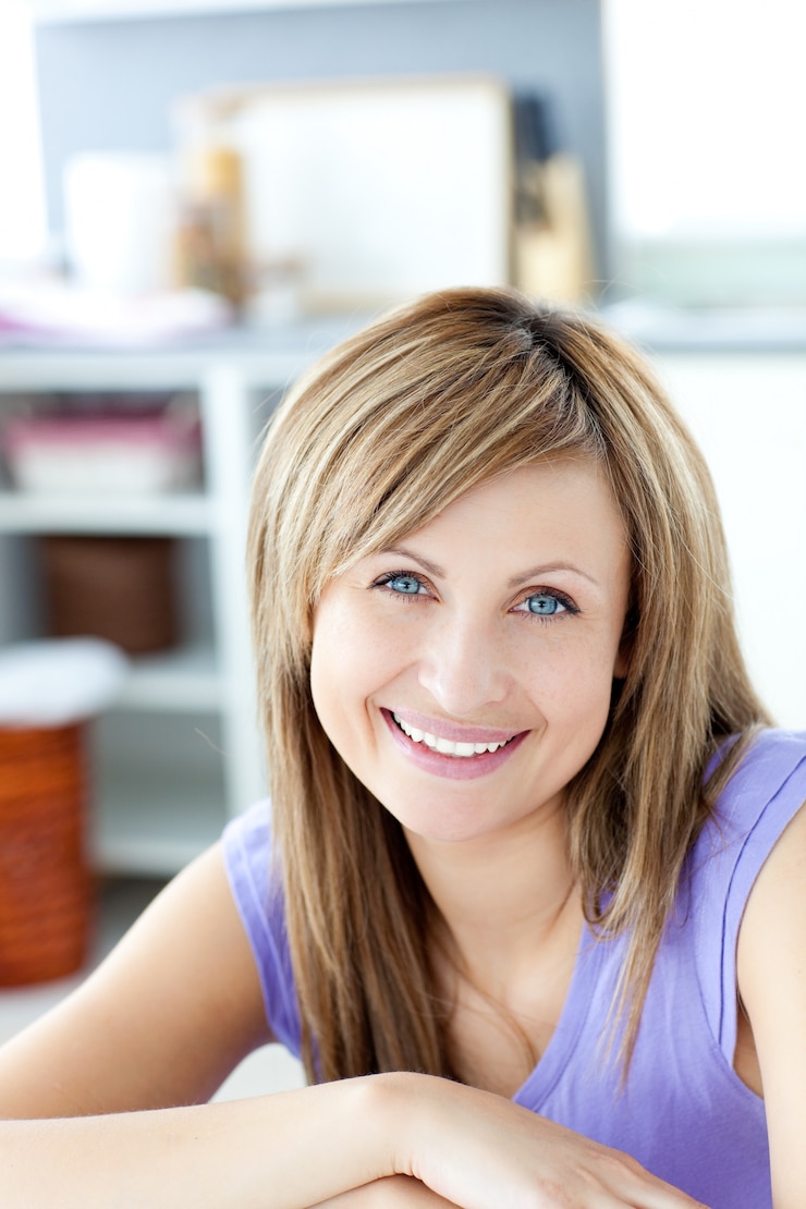 Fotografie smiling woman looking at the camera the kitchen 