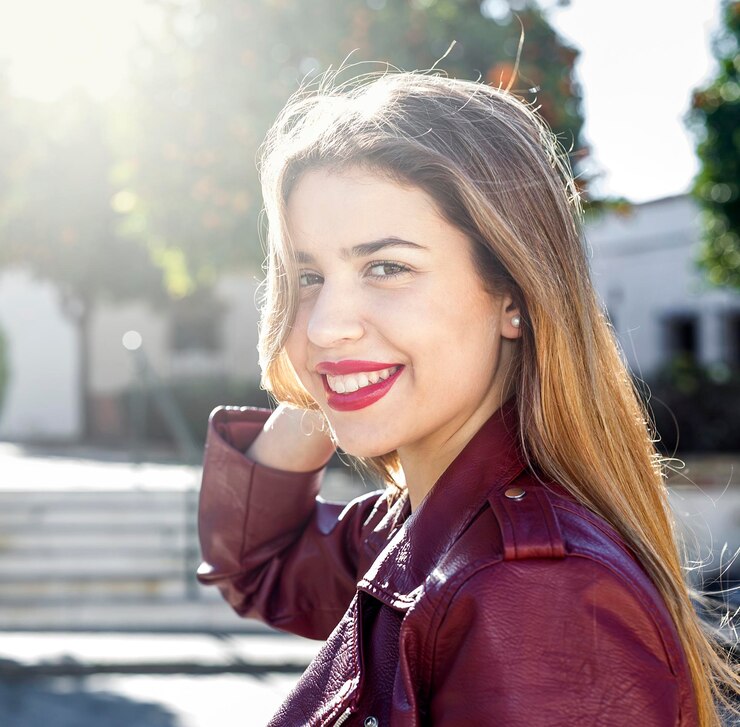 Fotografie smiling young woman wearing maroon jacket