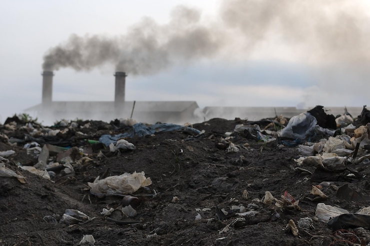 Fotografie smoke emitting from chimney on land against sky