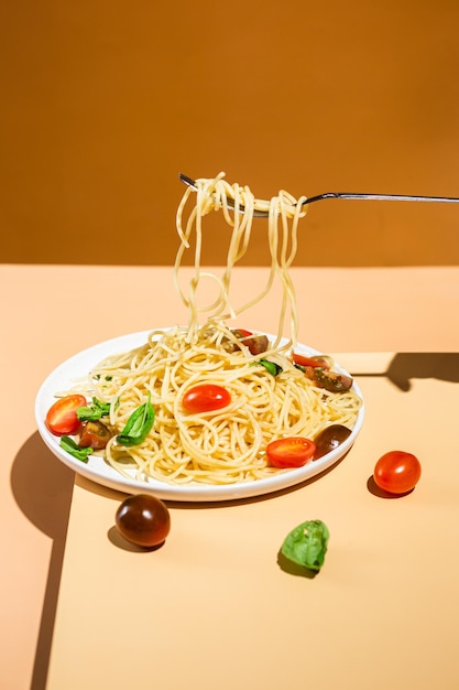 spaghetti with cherry tomatoes and basil on a white plate