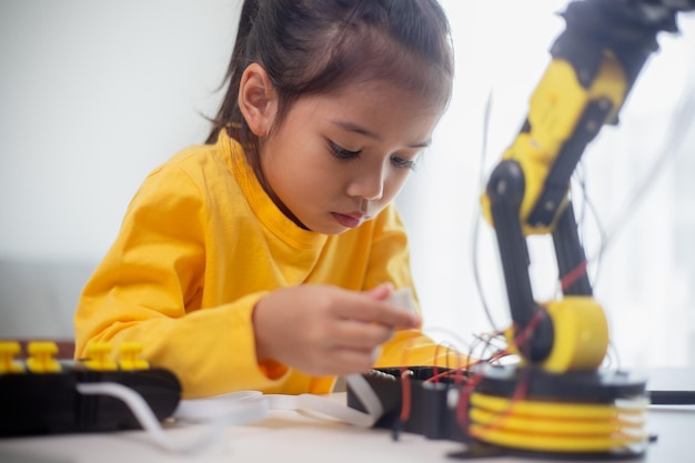 STEM education concept Asian students learn at home by coding robot arms in STEM mathematics engineering science technology computer code in robotics for kids' concepts