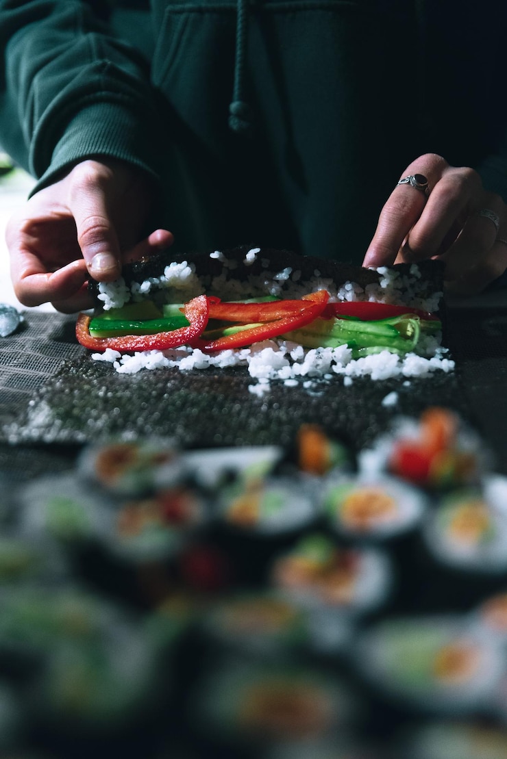 Fotografie střední část muže připravujícího sushi na stole