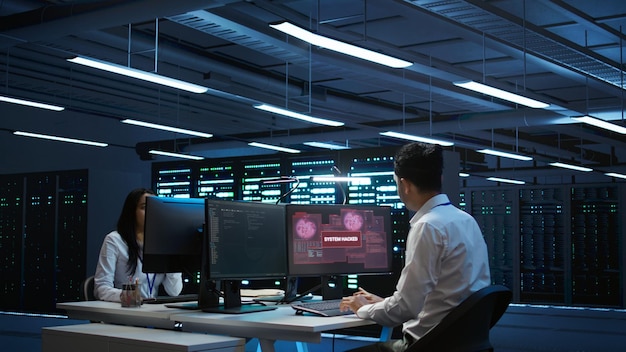 Team of programmers in server hub trying to protect hardware from hacker