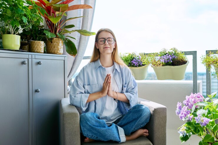 Fotografie teenage girl praying relaxed sitting at home in armchair on balcony
