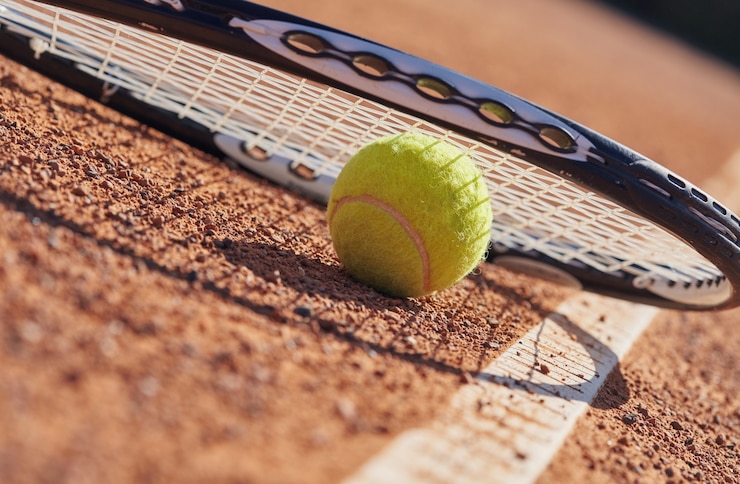 Fotografie tennis balls and racket on the claycourt
