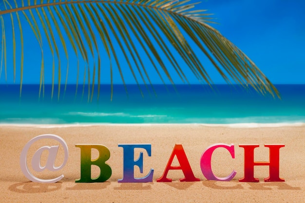 Text on sand at beach against sky