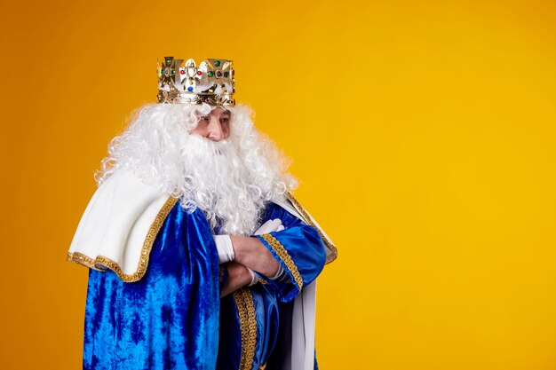 the magician king with crossed arms on a yellow background