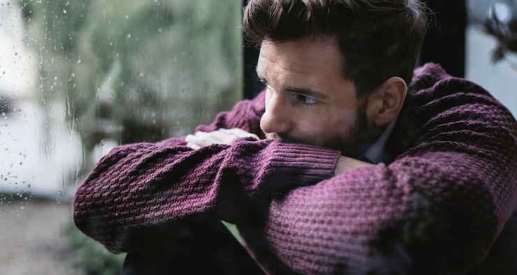 Fotografie thoughtful man looking out the window