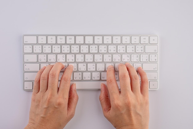 Top view of the human hand is typing on the keyboard isolated white background with clipping path