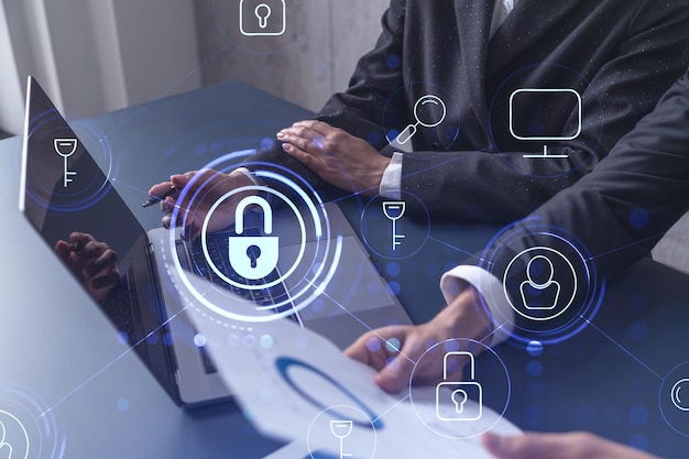 two business people working on the project to protect cyber security of international company using laptop padlock hologram icons teamwork concept