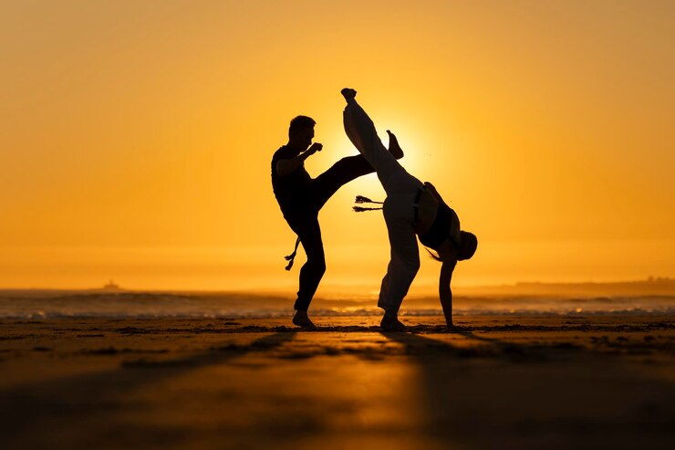 Fotografie two people practicing capoeira martial arts at sunset on the beach