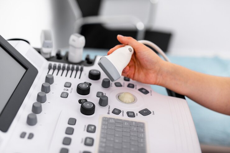 Fotografie ultrasound sensor of modern ultrasonic scanner in young woman doctor's hands