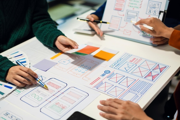 UX developer and ui designer brainstorming about mobile app interface wireframe design with customer breif and color code User experience concept