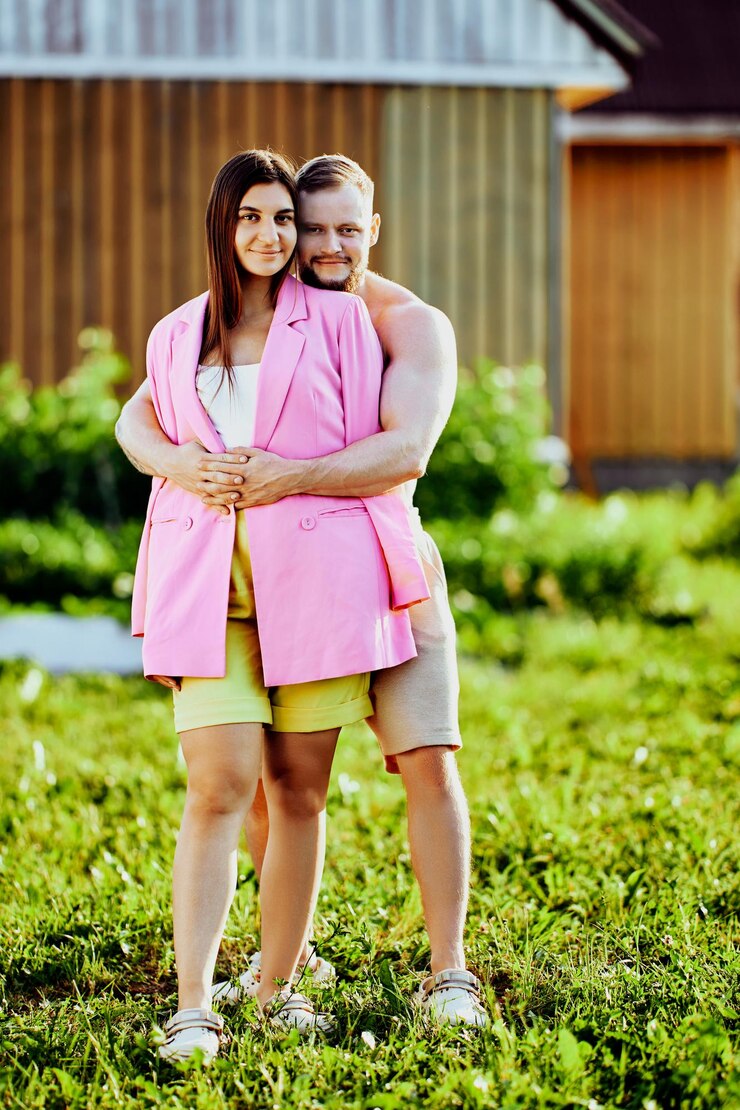 Fotografie vertical portrait of young white married couple man and woman in their s posing standing in garden