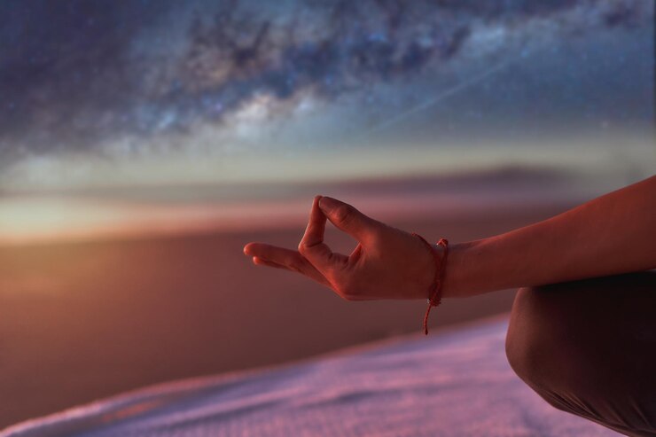Fotografie view of hand in meditation or yoga mudra position outdoors on the beach at night
