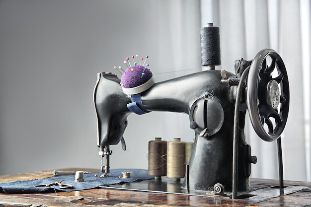 Vintage sewing machine with fabric and threads indoors