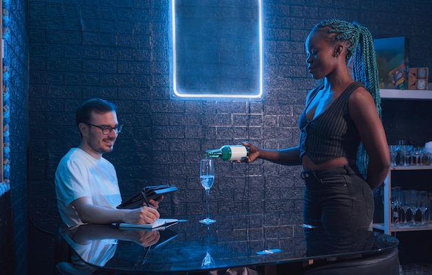 waitress black woman serving a customer a drink inside a pub