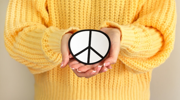 Fotografie woman holding paper peace symbol. freedom, love and peace concept