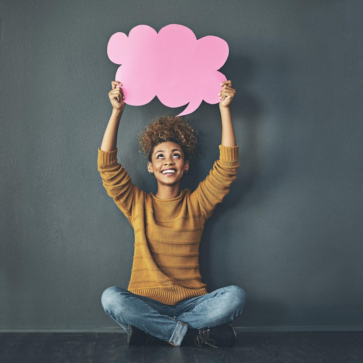 Fotografie woman holding thought bubble chat and speech board for voice opinion chatting on social media and showing idea smiling excited creative thinking of promotion strategy plan or innovating vision
