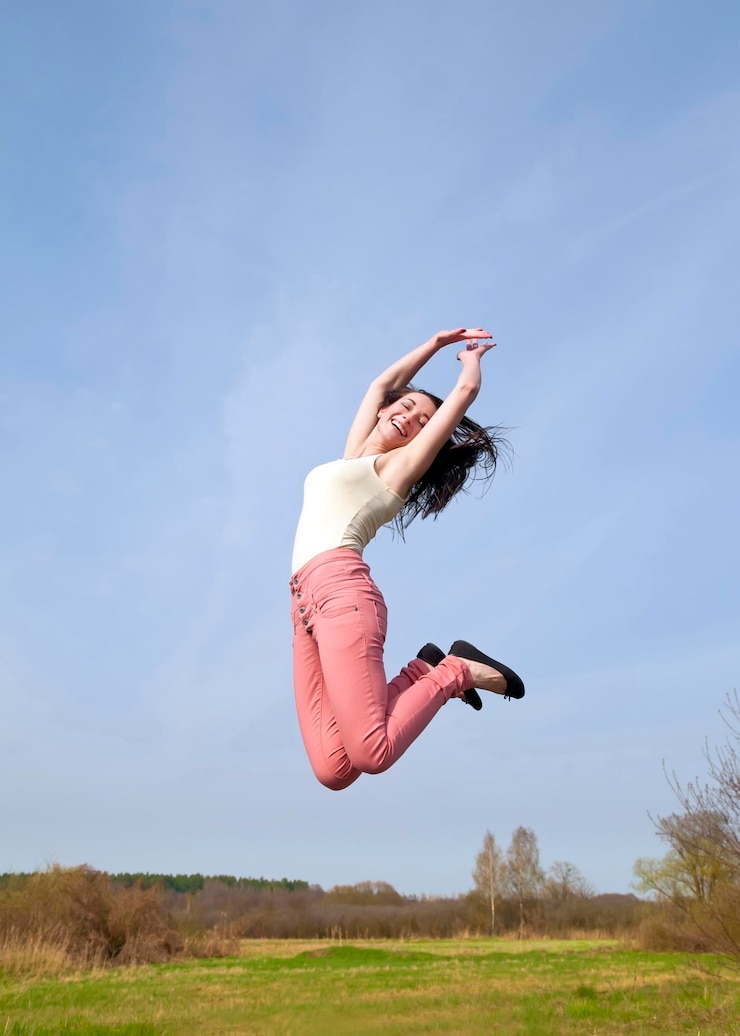 Fotografie woman jumping on field against sky