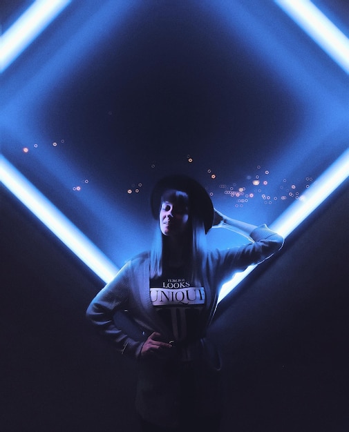 woman standing against illuminated blue light
