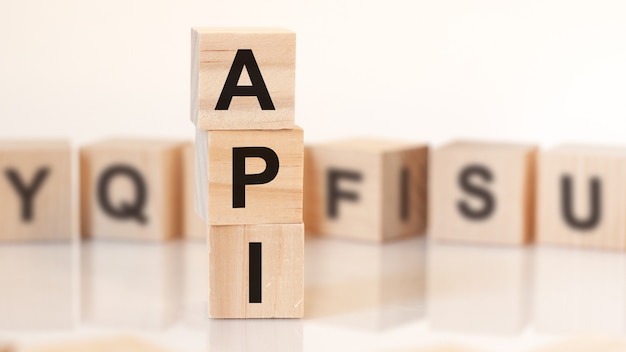 Wooden cubes with letters API arranged in a vertical pyramidbusiness concept. API short for application programming interface