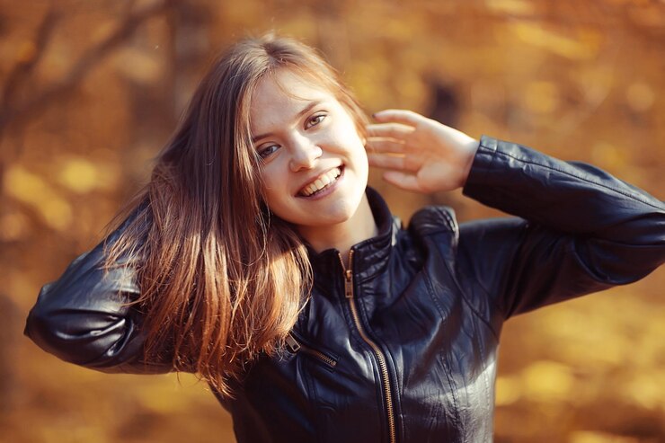 Fotografie young adult girl portrait in autumn park yellow leaves background