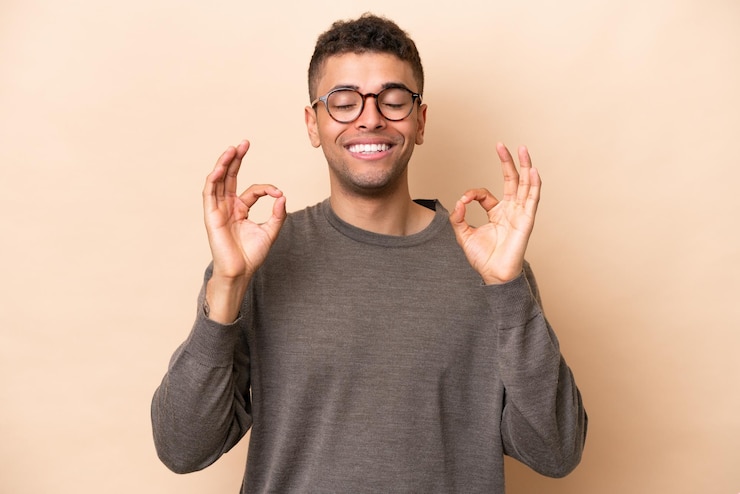 Fotografie young brazilian man isolated on beige background in zen pose