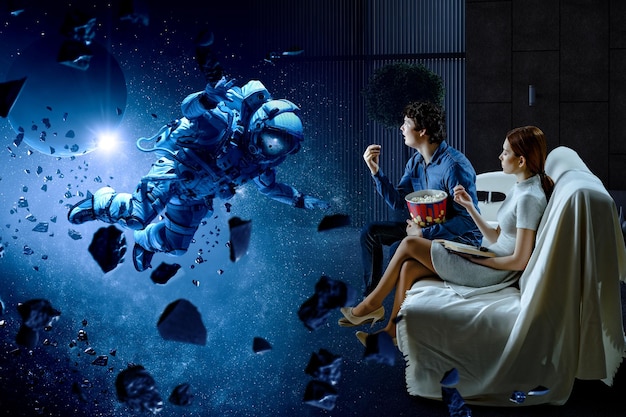 young couple watching 3d movie in cinema. mixed media