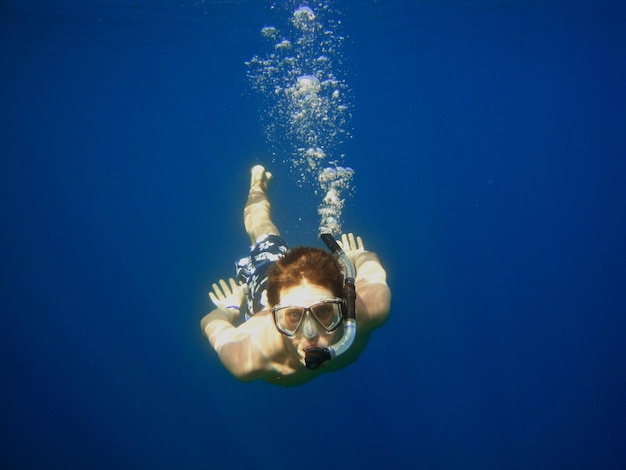 young man looking at camera while snorkeling