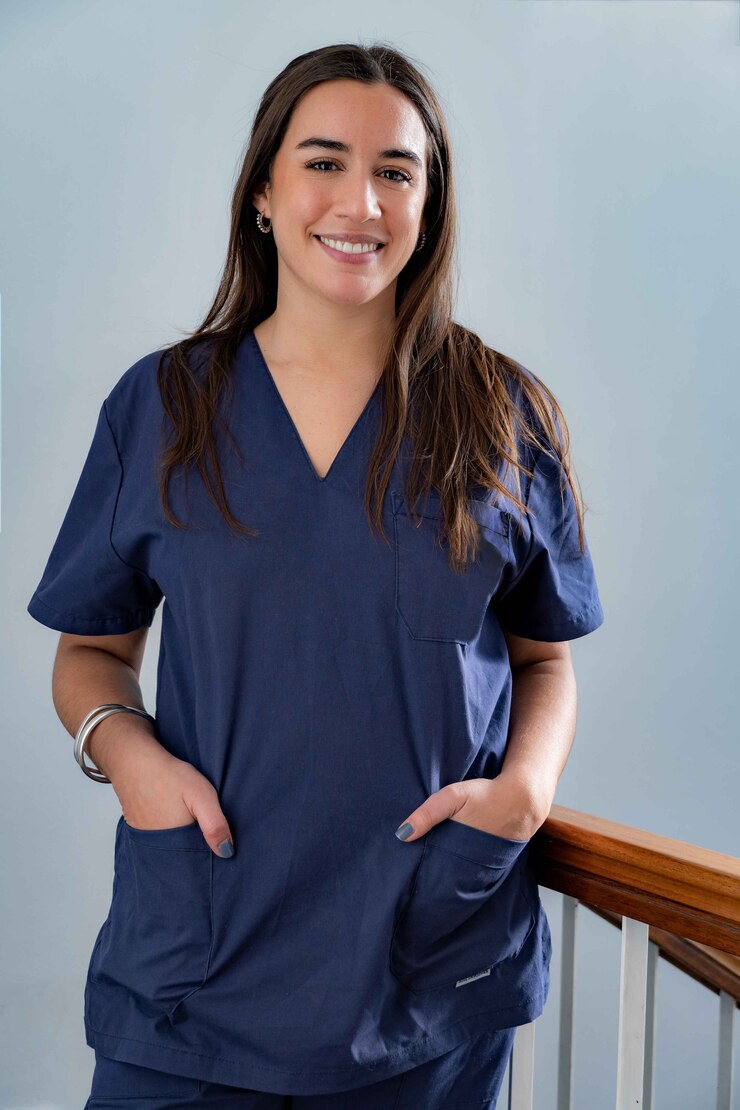 Fotografie young smiling young female doctor dentist in dark blue uniform standing in hallway