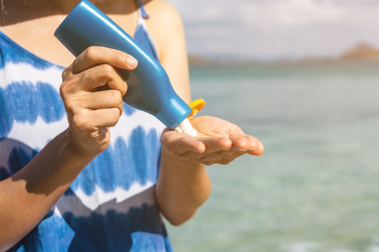 Fotografie young woman traveler applying sunscreen lotion the tropical beach