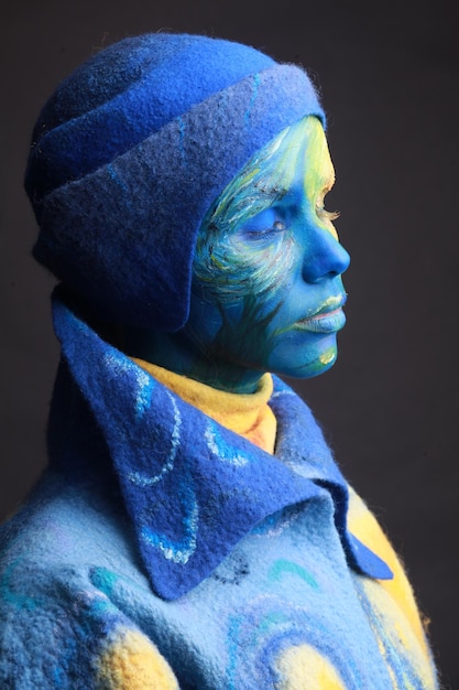 young woman with painted face against black background