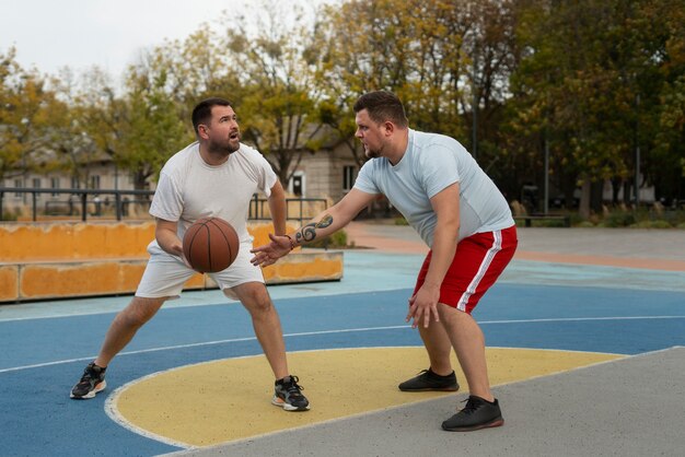 authentic scenes of plus-size males playing basketball