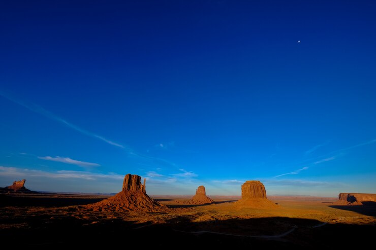 Zdarma Fotografie beautiful shot of a road in the middle of the desert with big cliffs in the distance