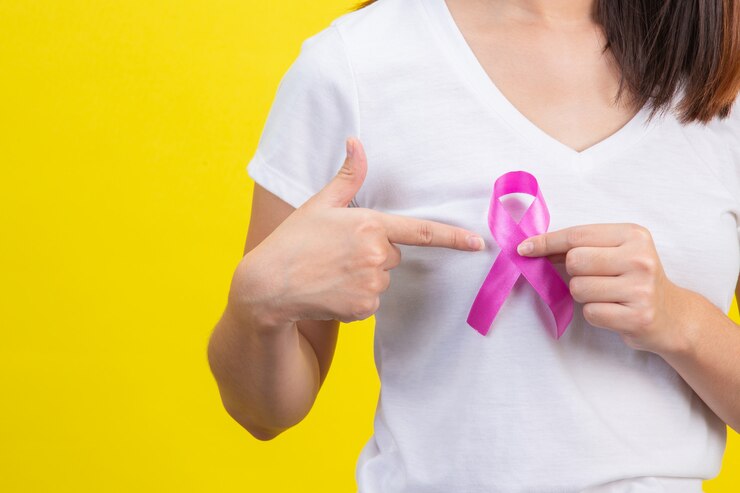 Zdarma Fotografie breast cancer , a woman in a white t-shirt with a satin pink ribbon on her chest, a symbol for breast cancer awareness 