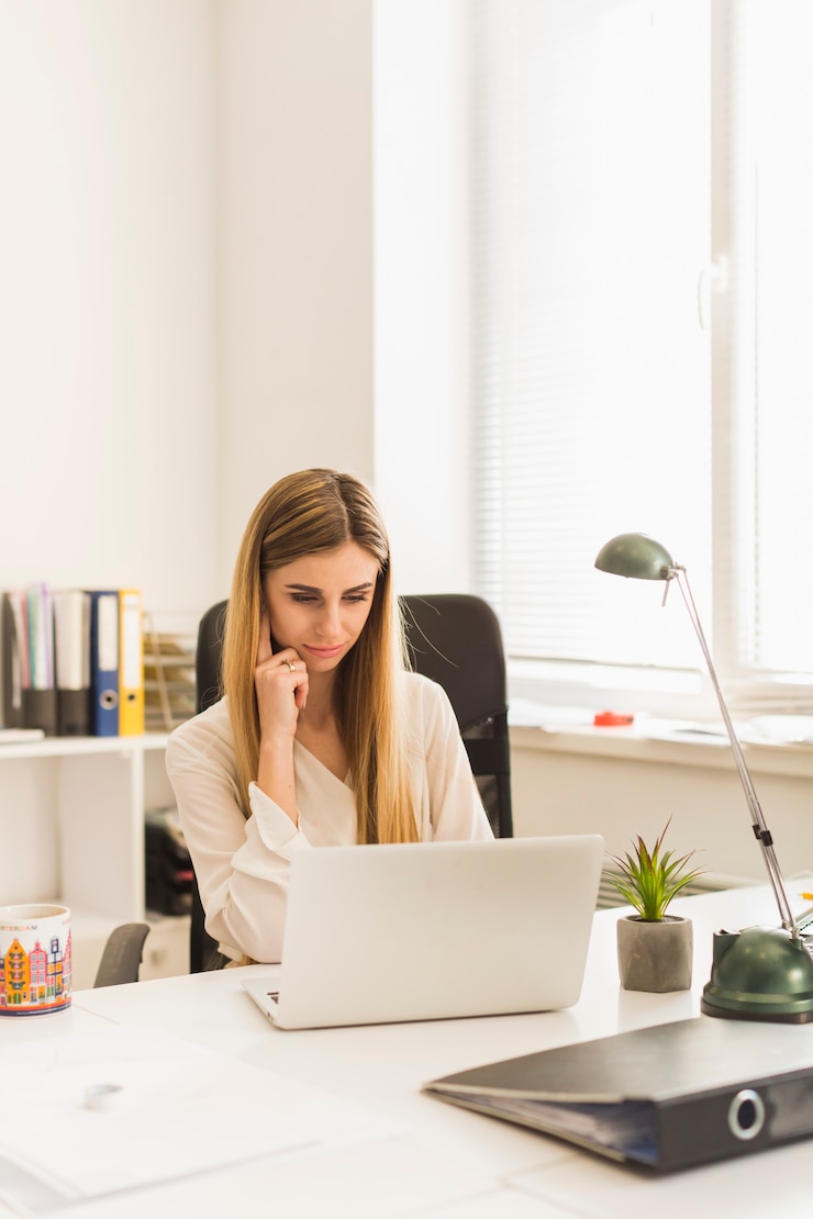 Zdarma Fotografie charming woman browsing laptop in office