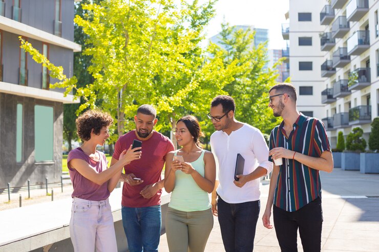 Zdarma Fotografie cheerful woman showing phone screen to her excited peers