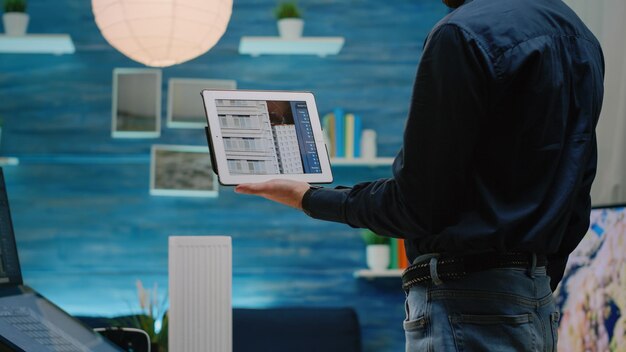 Close up of architect using tablet with touch screen to analyze building model for architectural development. Man engineer working with device for construction layout and design.