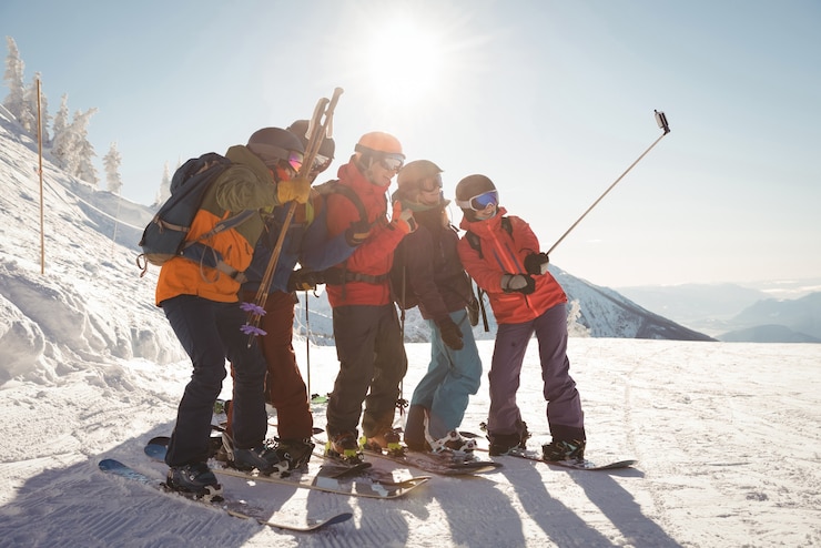Zdarma Fotografie group of skiers taking selfie on mobile phone