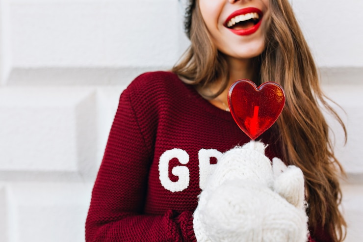 Zdarma Fotografie heart red candy holding by girl in white gloves. she has long hair, snow white smile, red lips.