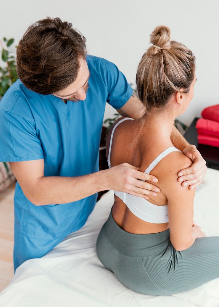 Zdarma Fotografie high angle of male osteopathic therapist checking female patient's scapula